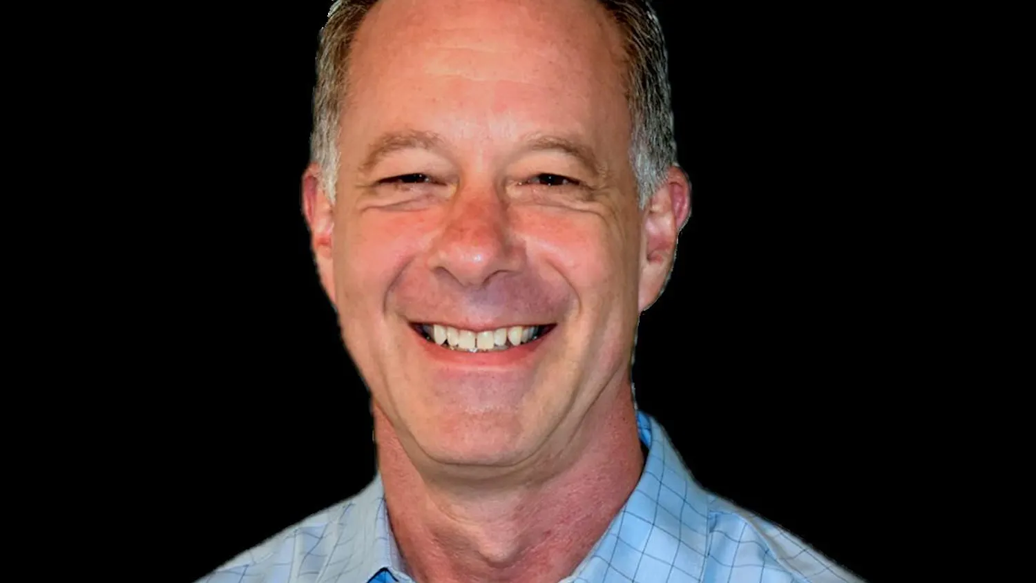 A headshot of a man smiling.