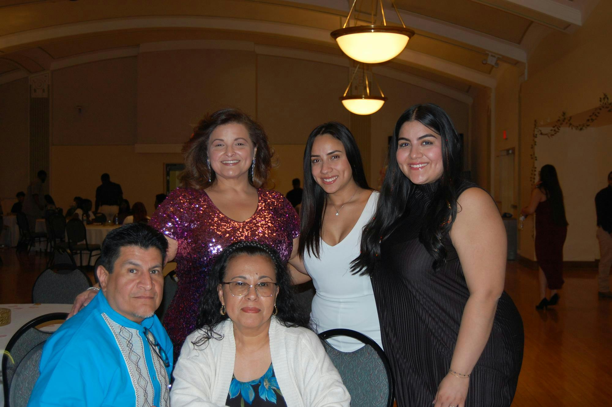 Five alumni and friends of the Latinx Student Association take a break from the dancing to pose for a photo at the sixth annual Quinceanera in the McKenny Hall Ballroom. 