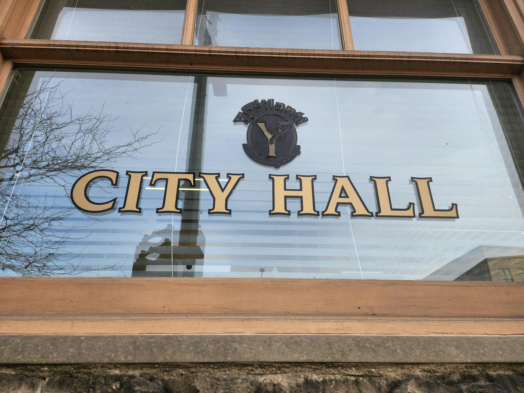 A close-up look at the City Hall building shows its window with the words "City Hall" displayed on it.