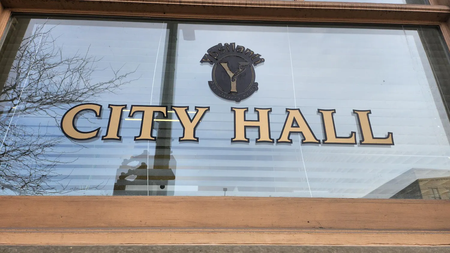 A close-up look at the City Hall building shows its window with the words "City Hall" displayed on it.