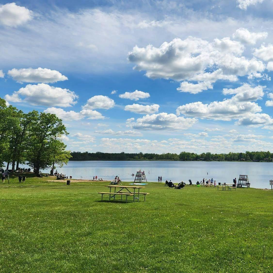 People at the beach sitting in chairs and in the water.
