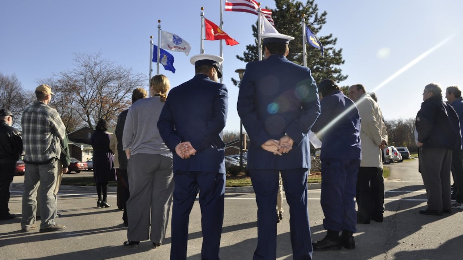 Two veterans of the U.S. Coast Guard stand in front of a new set of flags near Westview Apartments, which was the site of a ceremony Wednesday that saluted veterans. Every branch of the military is recognized by its own flag.