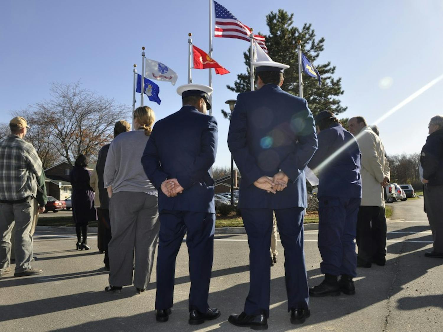 Two veterans of the U.S. Coast Guard stand in front of a new set of flags near Westview Apartments, which was the site of a ceremony Wednesday that saluted veterans. Every branch of the military is recognized by its own flag.