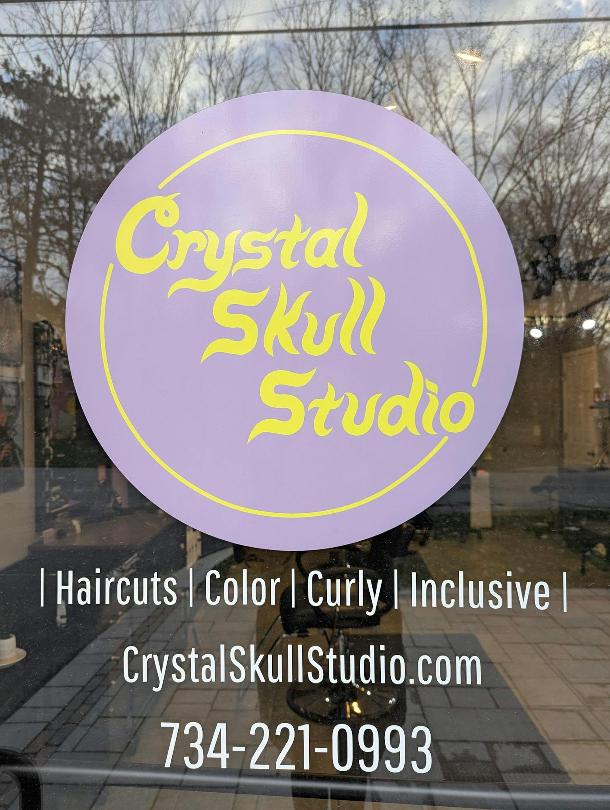 A purple logo on a door that says "Crystal Skull Studio."