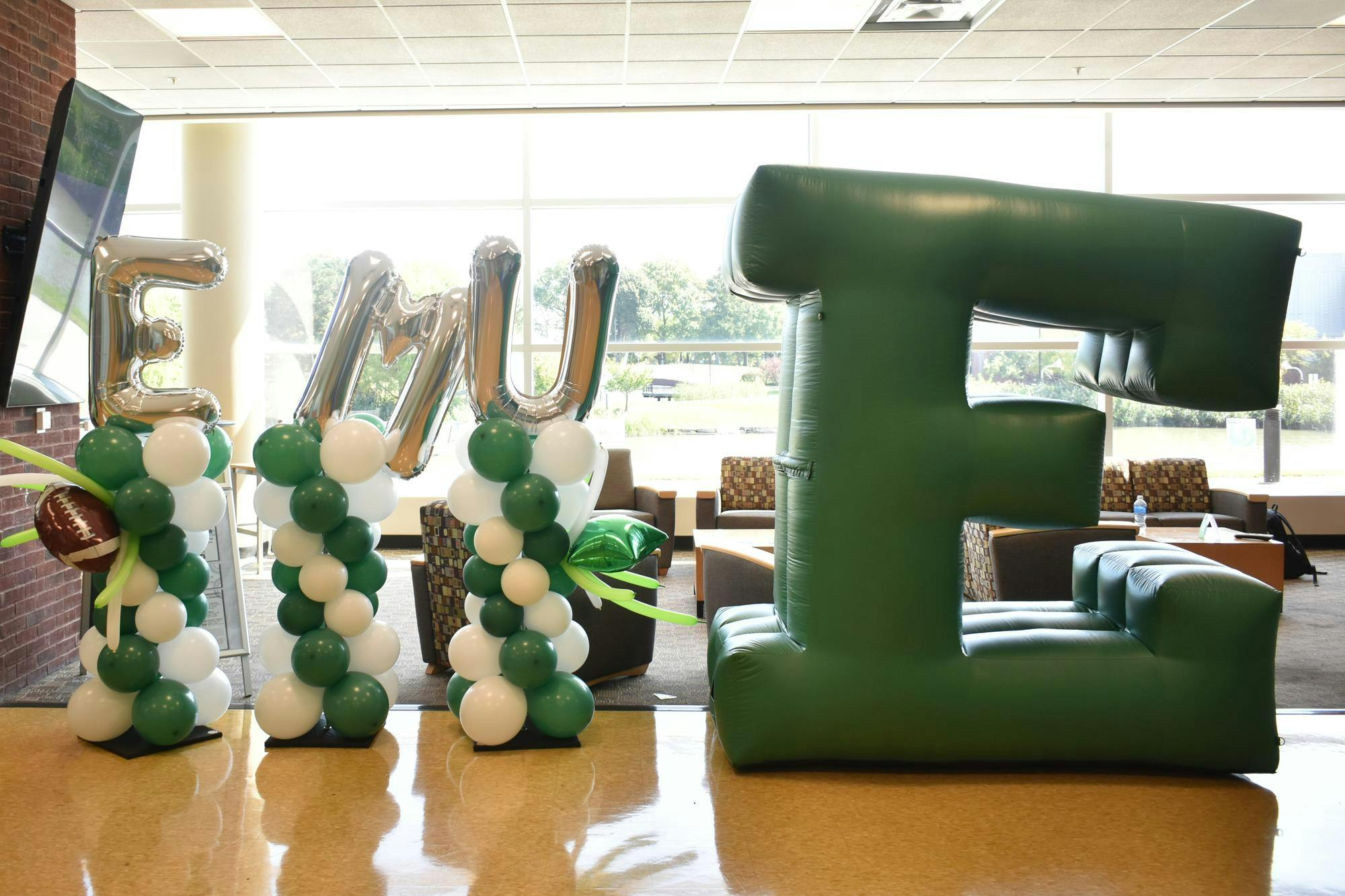 Balloons spelling out "EMU" are next to a big inflatable Block E.