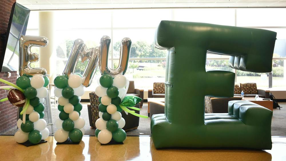 Balloons spelling out "EMU" are next to a big inflatable Block E.