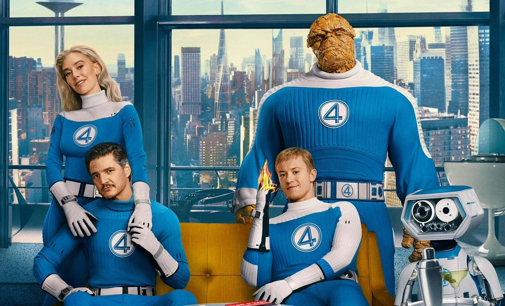 Sue Storm stands behind Mr. Fantastic and puts her hands on his shoulders while he sits on a couch in front of her. To the right of them, Johnny Storm also sits on the couch while Ben Grimm and Herbie stand behind and beside him, respectively.