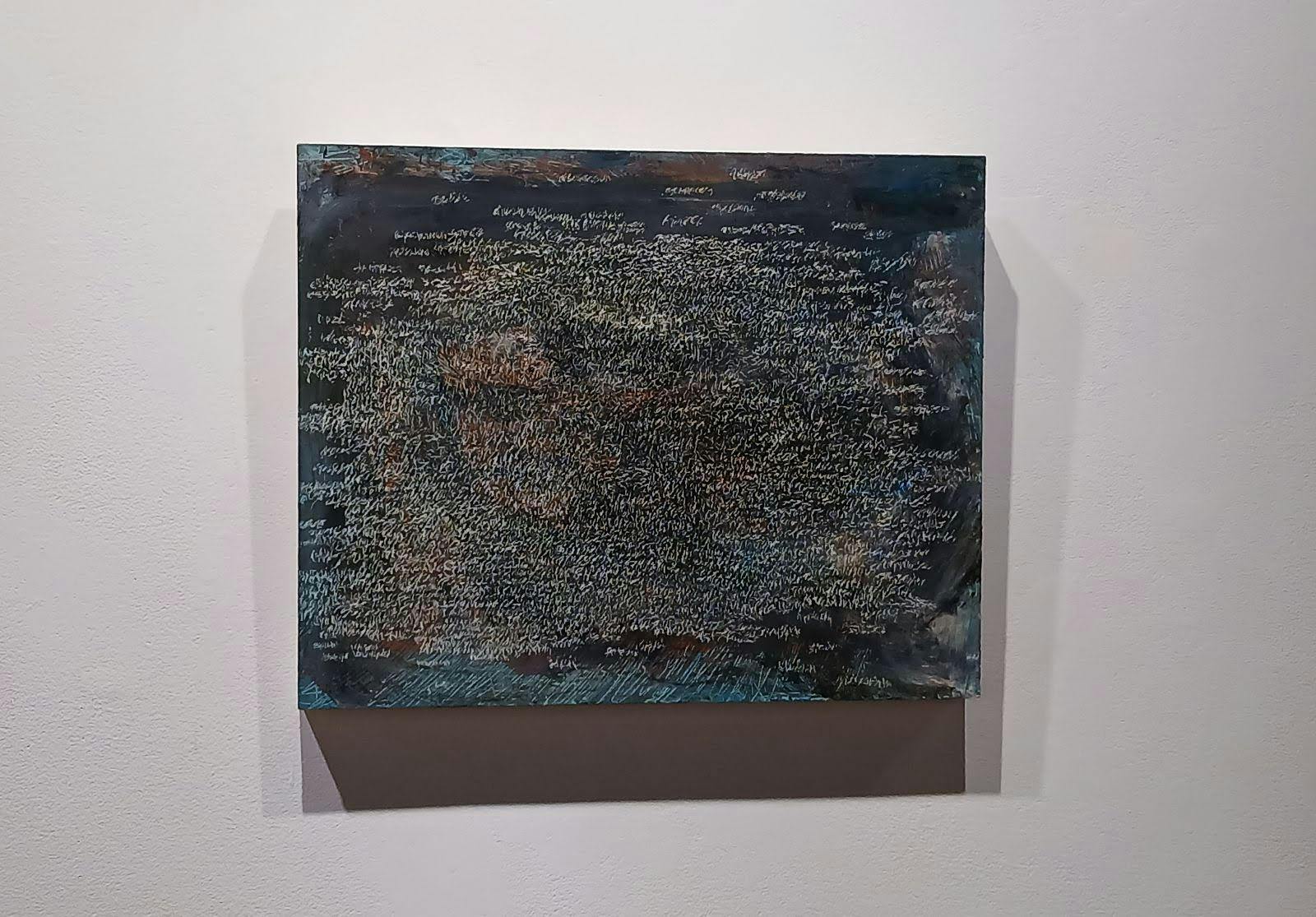 An abstract painting of scratches on a blue background hanging on a white wall.