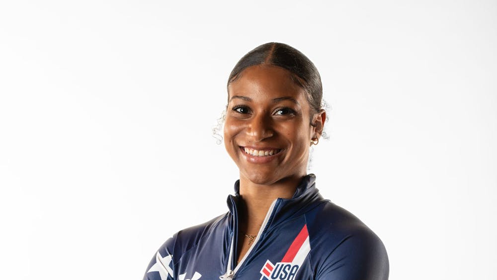 Headshot of Olympian Jasmine Jones, smiling and crossing her arms in Olympic gear.