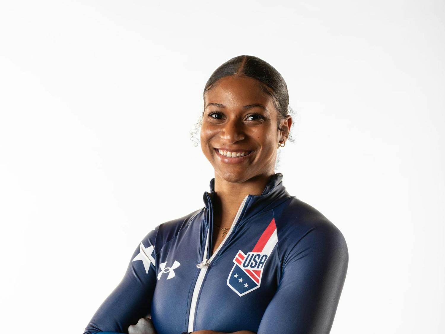 Headshot of Olympian Jasmine Jones, smiling and crossing her arms in Olympic gear.