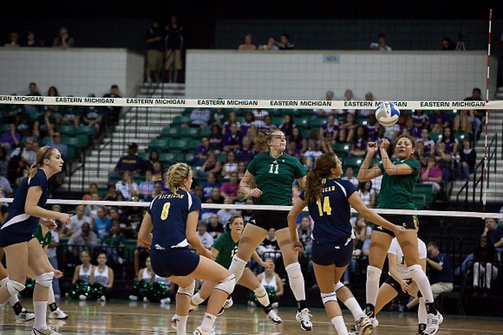 EMU’s Jennifer Swartz (11) watches as her teammate Rachel Iaquaniello hits the ball to the opposing Michigan side for a point.