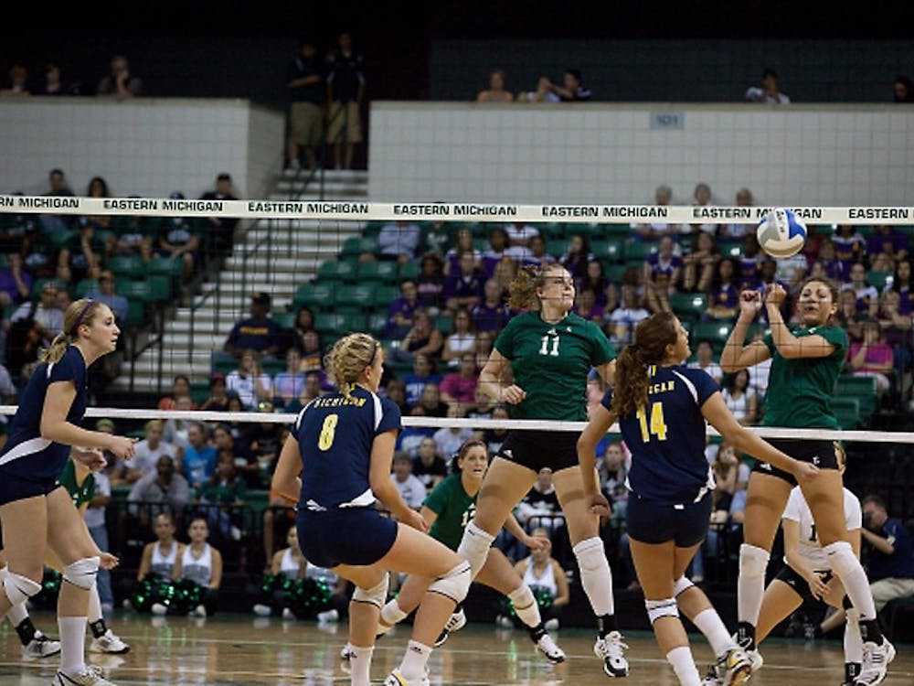 EMU’s Jennifer Swartz (11) watches as her teammate Rachel Iaquaniello hits the ball to the opposing Michigan side for a point.