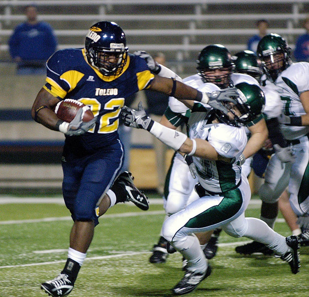 	Stiffarming tailback DaJuane Collins gains some of his 144 rushing yards in Toledo’s 47-21 win over EMU on Friday. Teammate Morgan Williams rushed for 155.