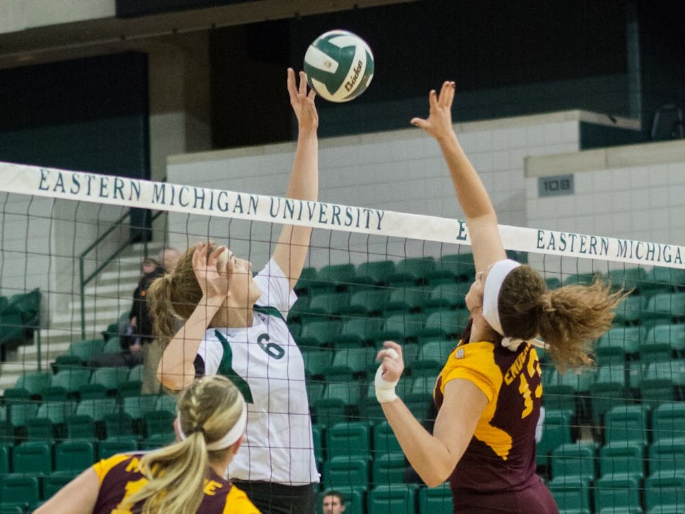 Jill Briner launches to tip the ball over the opponent's hands at the EMU vs. CMU volleyball game on October, 30 2014 at the Convocation Center