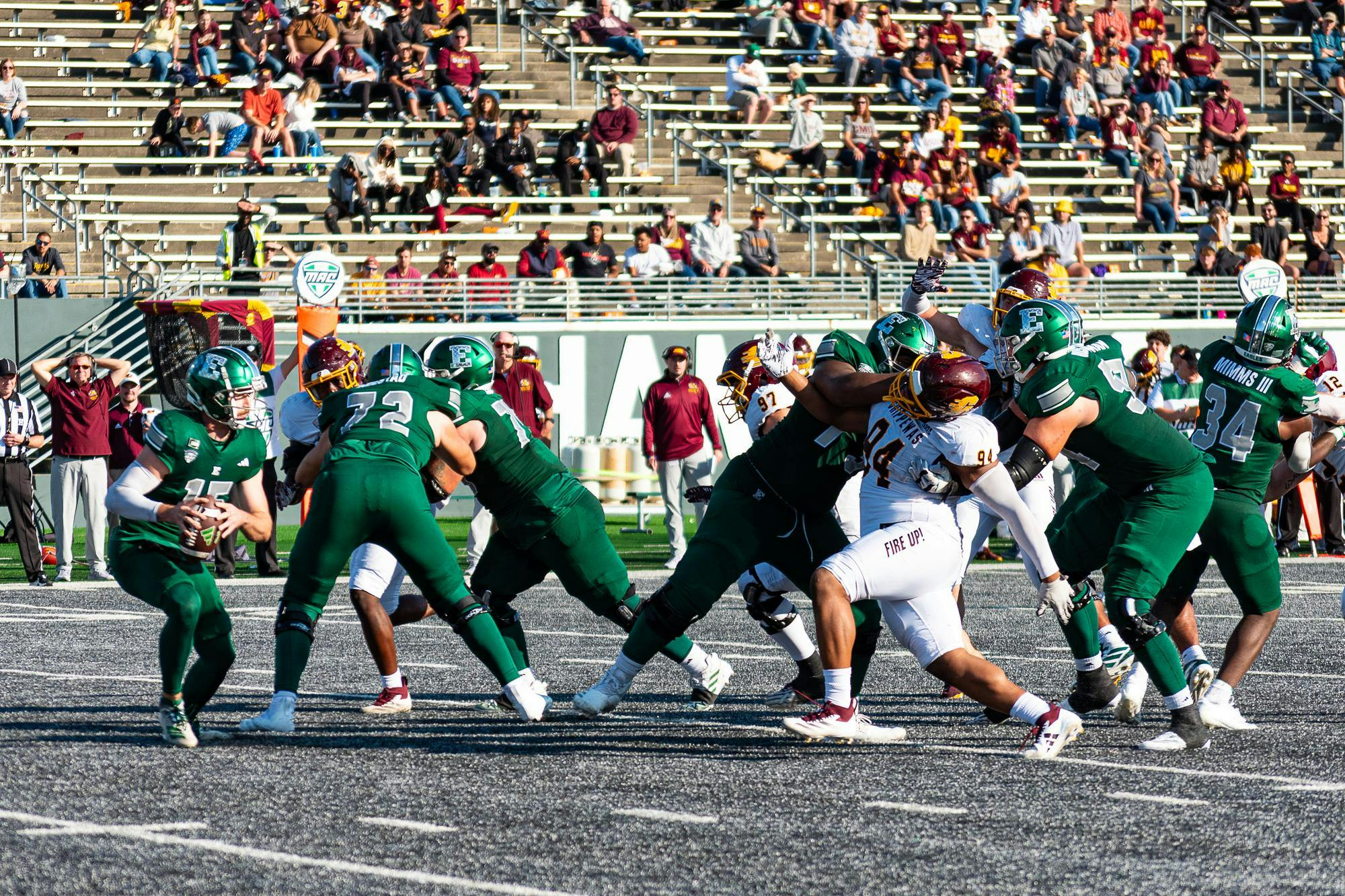 An Eastern Michigan player, the quarterback, holds the ball and surveys the field against Central Michigan.