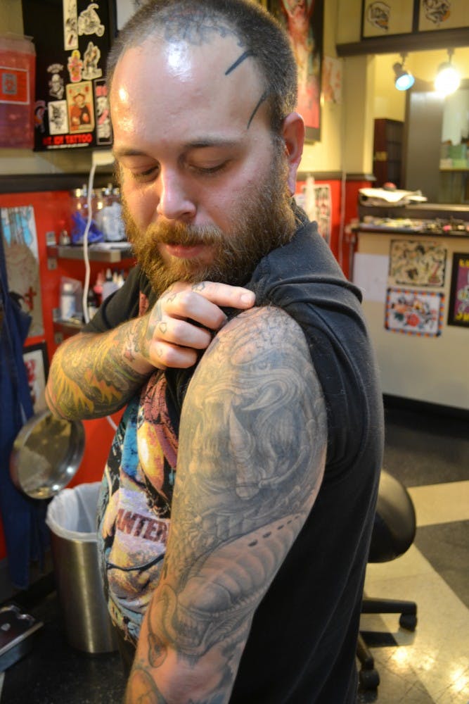 Tattoo artist Chris shows off some wicked ink including a gigantic spider on the side of his skull, whose legs appear to creep onto his face.