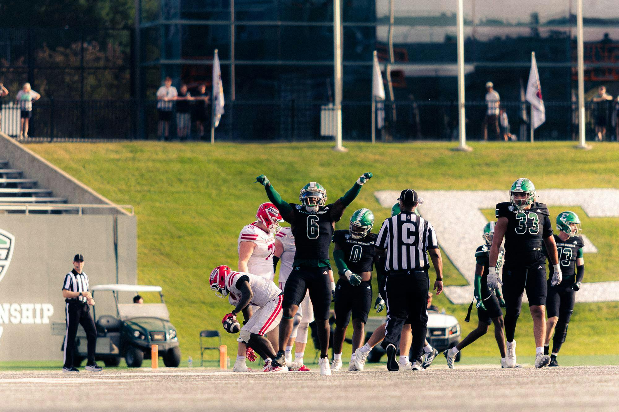 An Eastern Michigan player celebrating with his hands in the air after a defensive stop.
