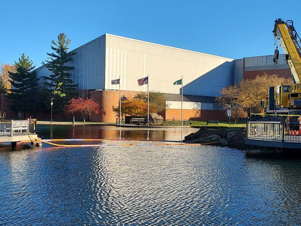 The arched bridge structure over the University Park pond has been removed, and the docks on either side of the water sit disconnected.