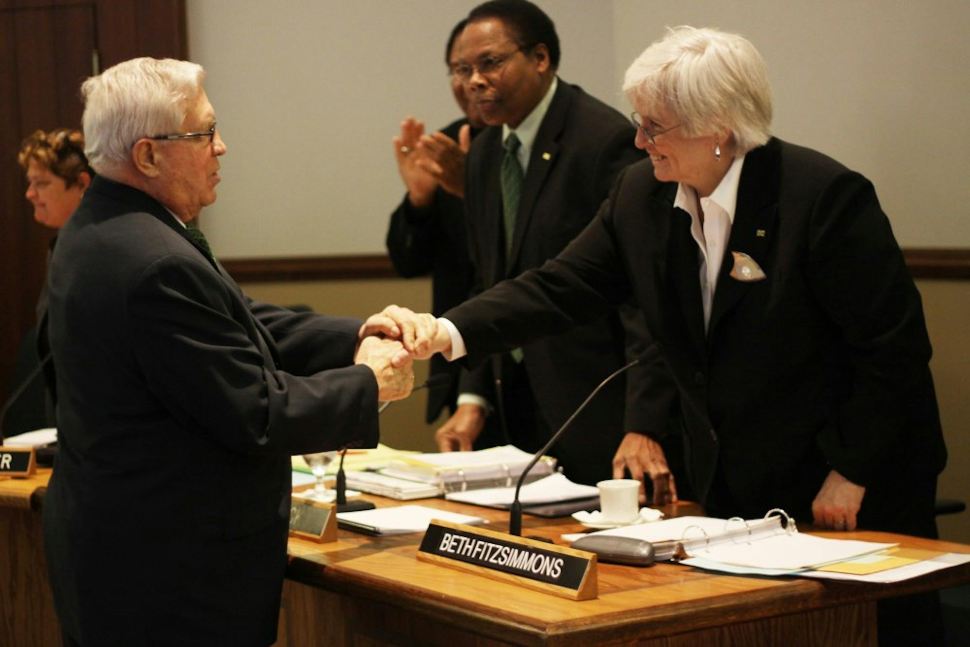 Former EMU Regents Gary Hawks, who was presented Emeritus Regent status Tuesday, shakes hands with new Regent Beth Fitzsimmons, who was recently appointed to the board by Rick Snyder to replace Mohamed Okdie.