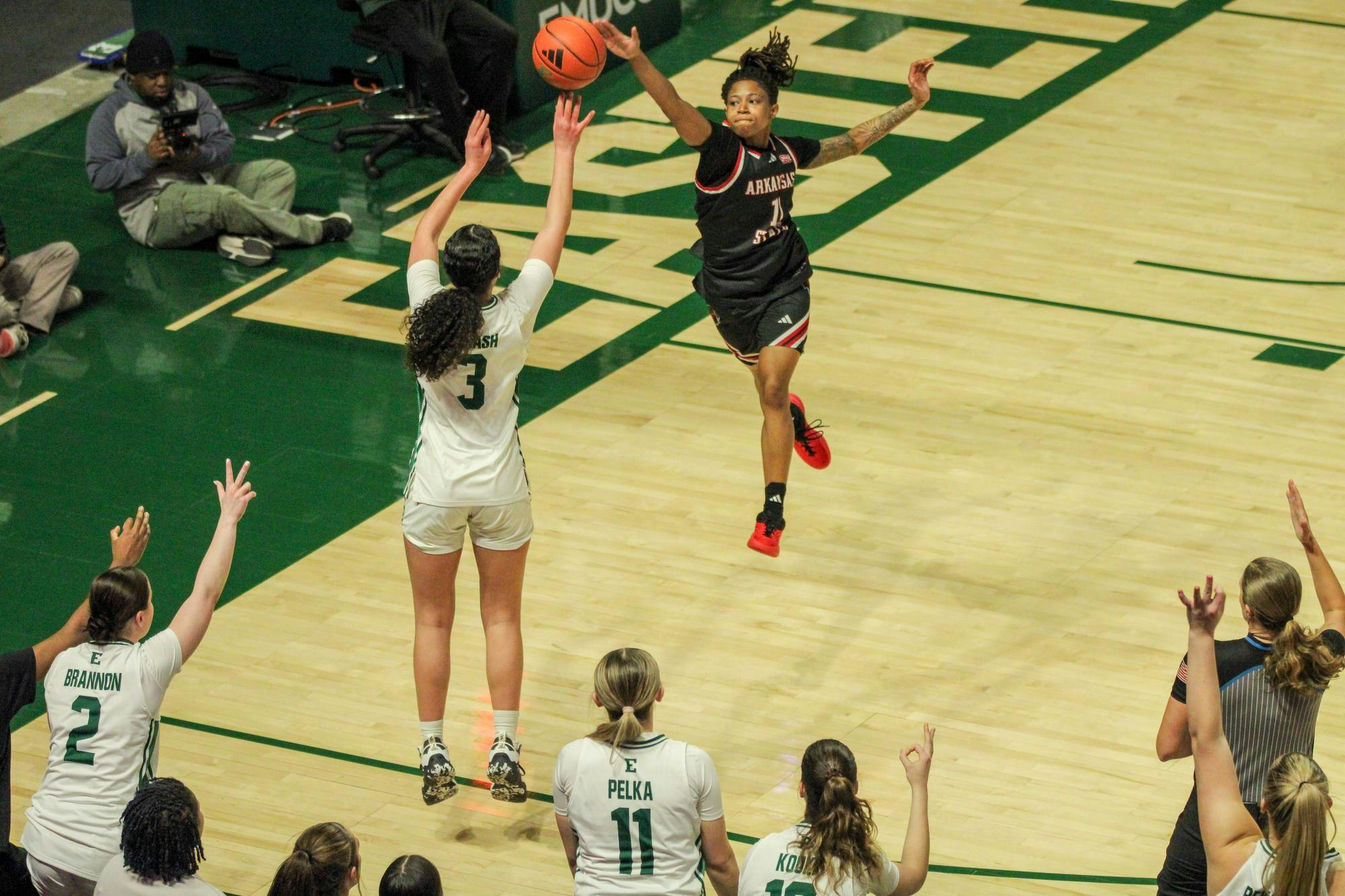 Eastern player, No. 3 in a white jersey, jumping to make a three-point shot.