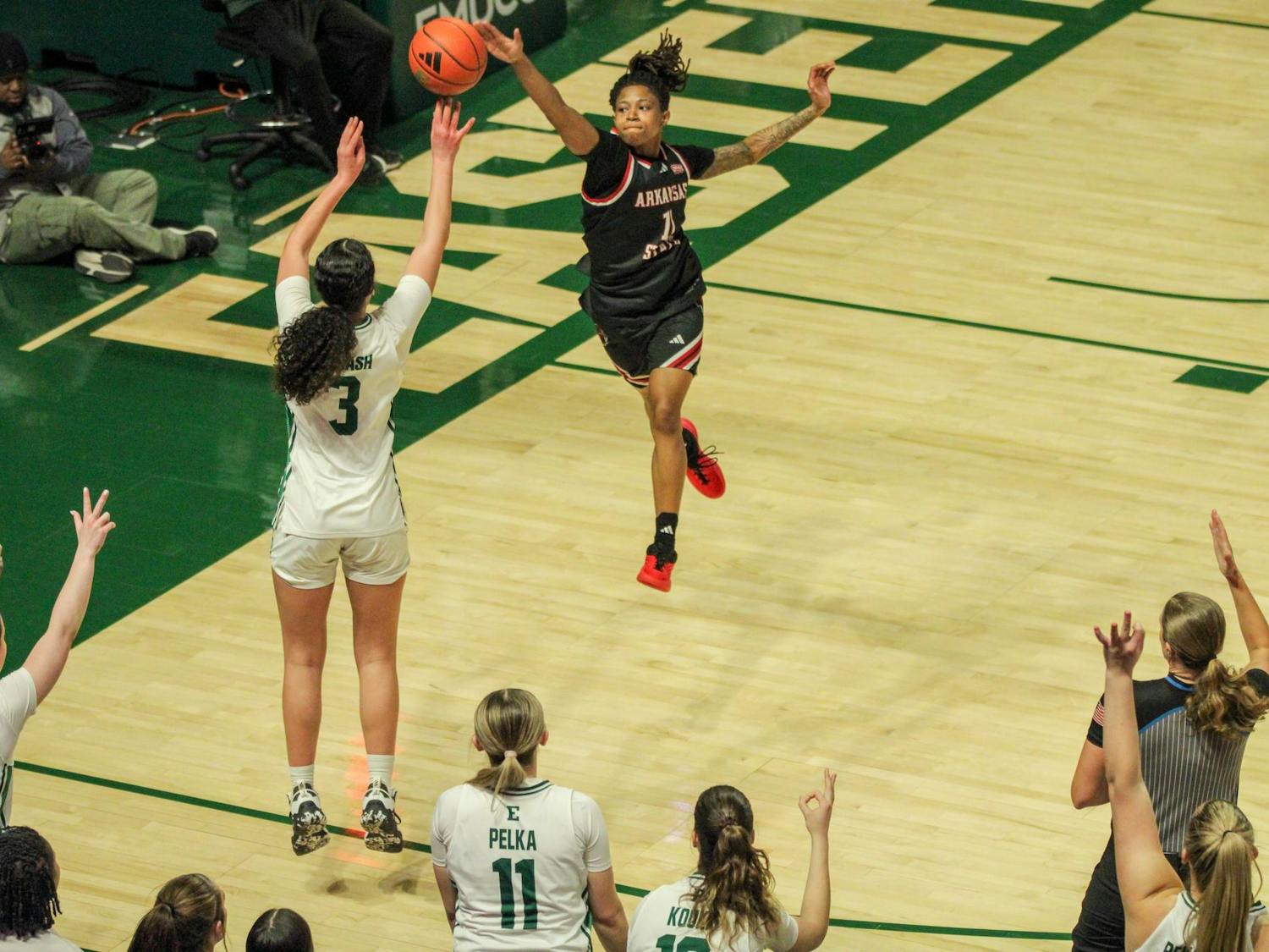 Eastern player, No. 3 in a white jersey, jumping to make a three-point shot.