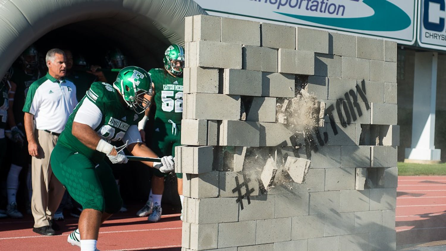 Eastern Michigan players break through a cinder block wall before the Eagles' 61-14 win over Mississippi Valley State in Ypsilanti, 2 Sept.