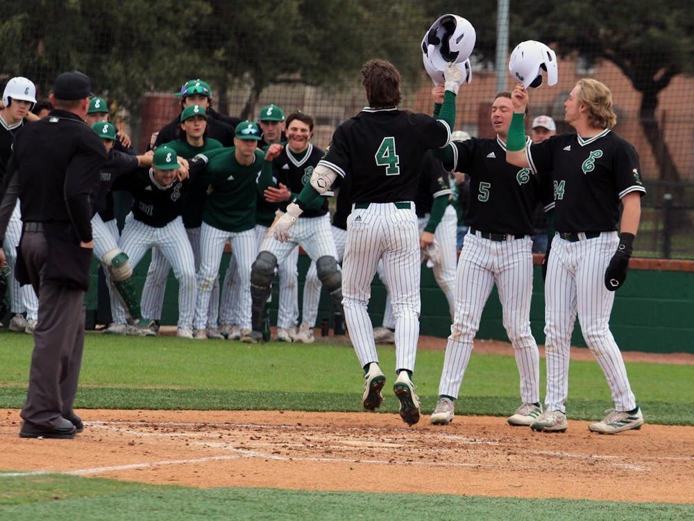 The Eastern Michigan University baseball team tips their caps as sophomore Cooper Vance (number 4) comes into home after a home run           