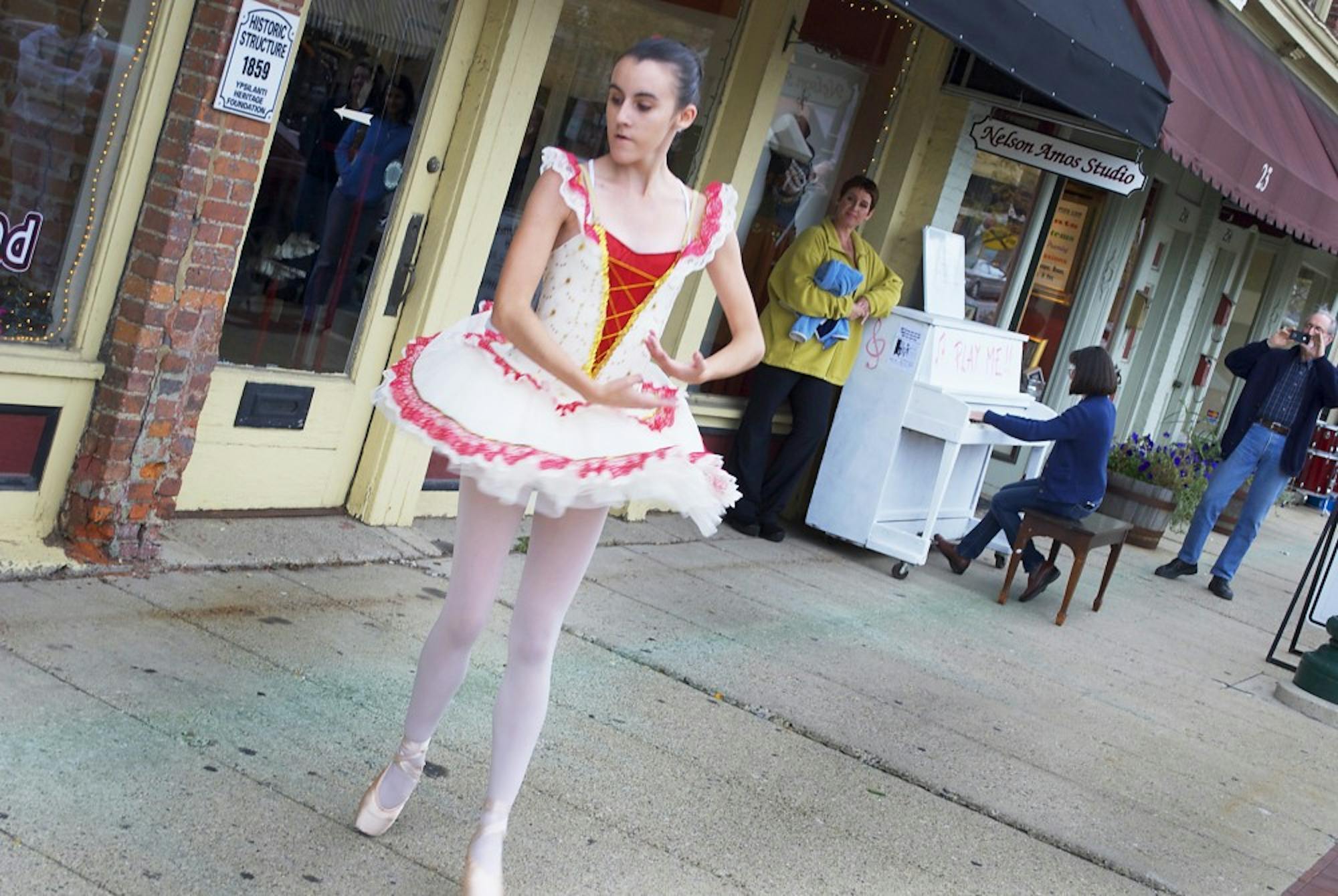 Ballerina Nicasia Marie performs en-pointe for the entranced crowd as Pianos ‘Round Town creator Korin Hancherlian-Amos plays piano Saturday in Depot Town. The event will continue until October 11.