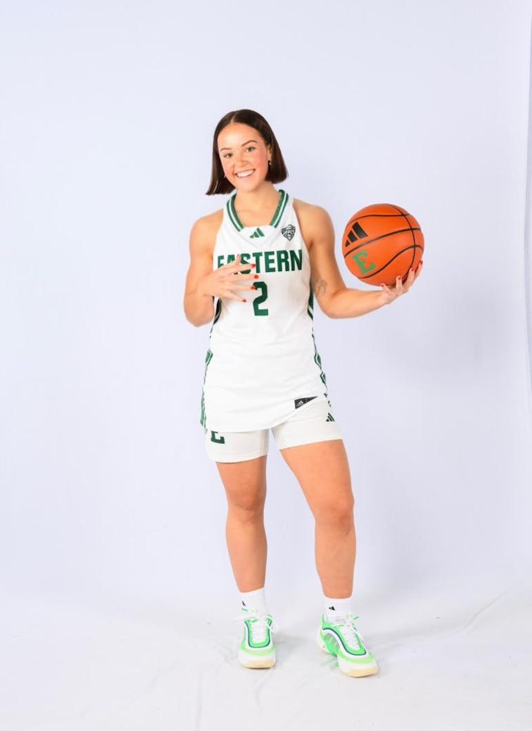 Ruby Brannon poses in the Eastern Michigan University basketball team jersey against a white background, holding a basketball.