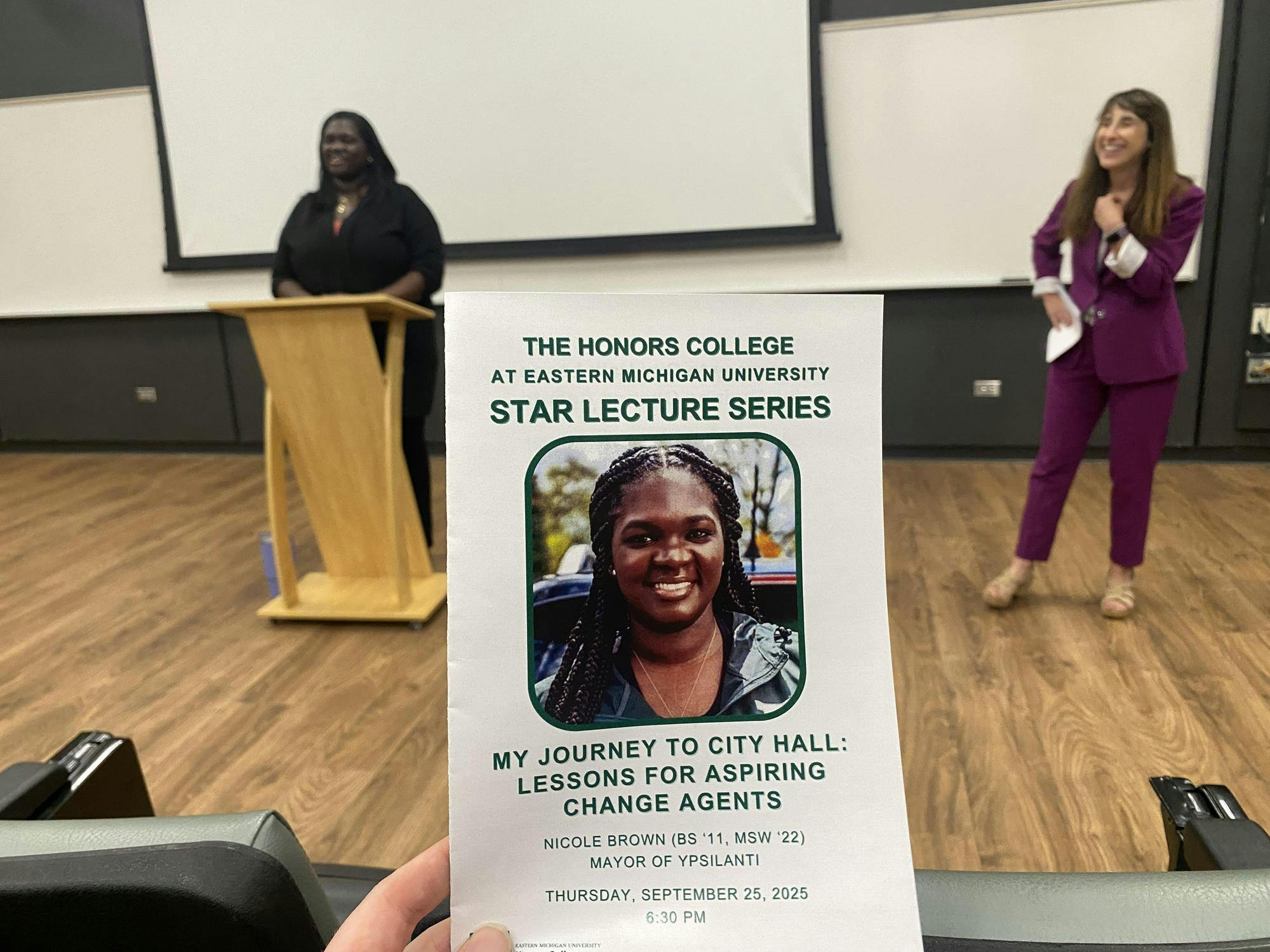 Brochure for the Star Lecture series with headshot of Mayor Nicole Brown. Brown stands at a lectern in the background with Ann Eisenberg in a purple dress suit to her right.