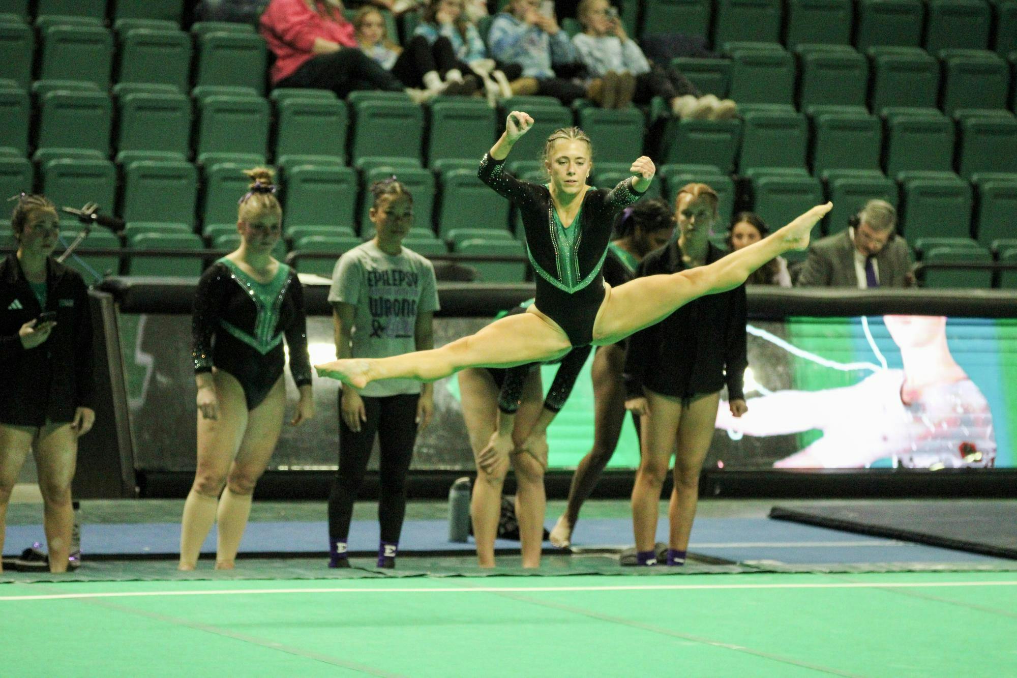 EMU gymnast, Abby Brushwood, doing the splits in the air. 