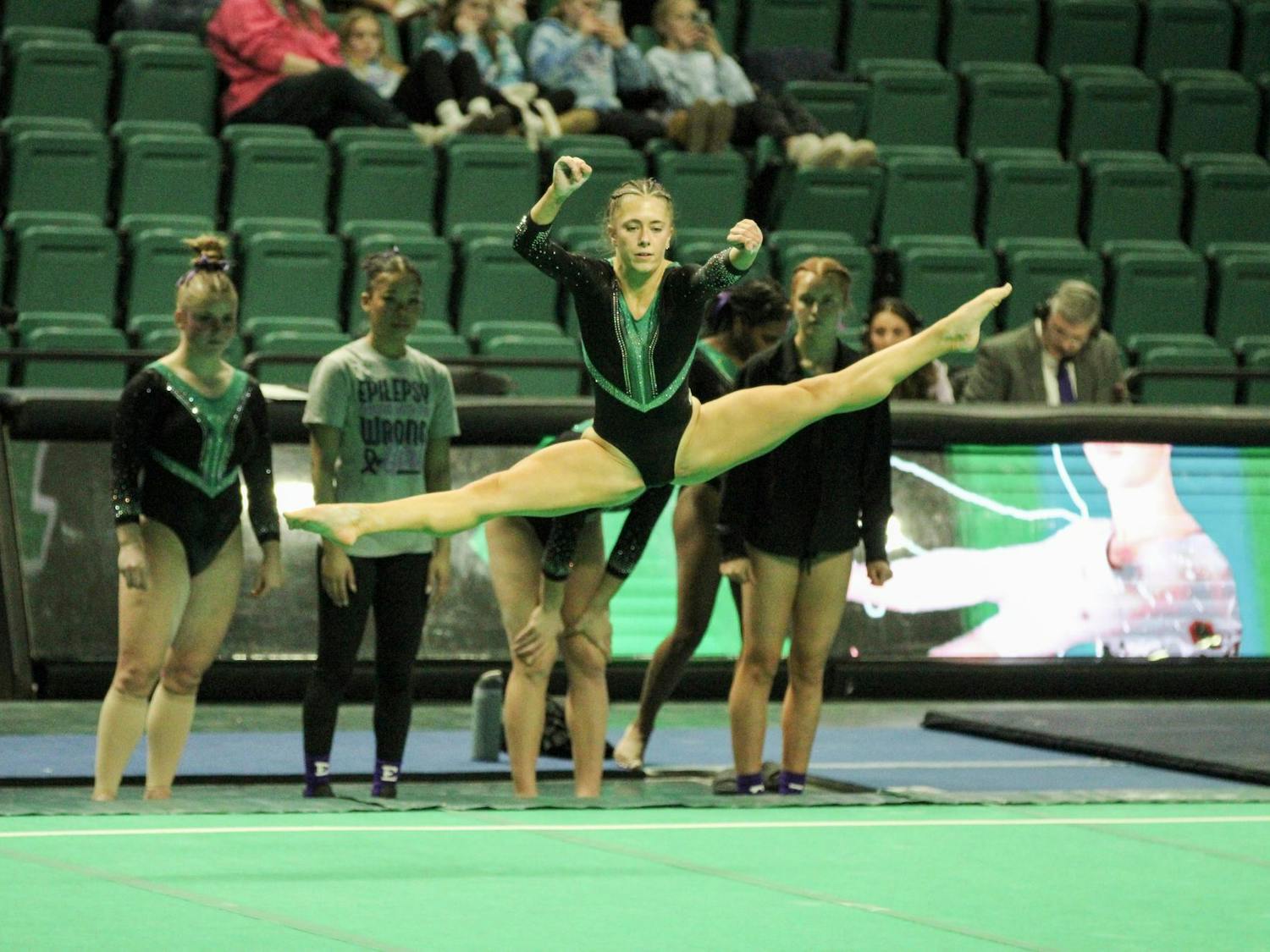 EMU gymnast, Abby Brushwood, doing the splits in the air.