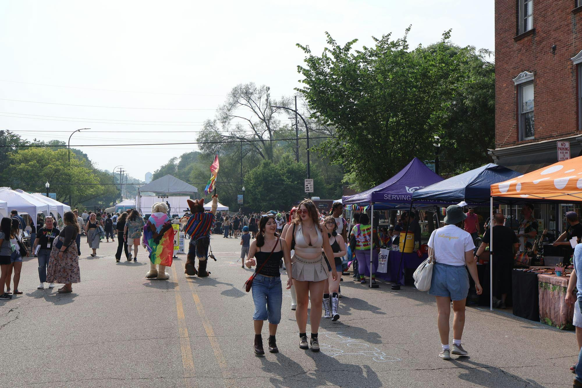 A crowd of people smiling as they explore Ypsi Pride 2025