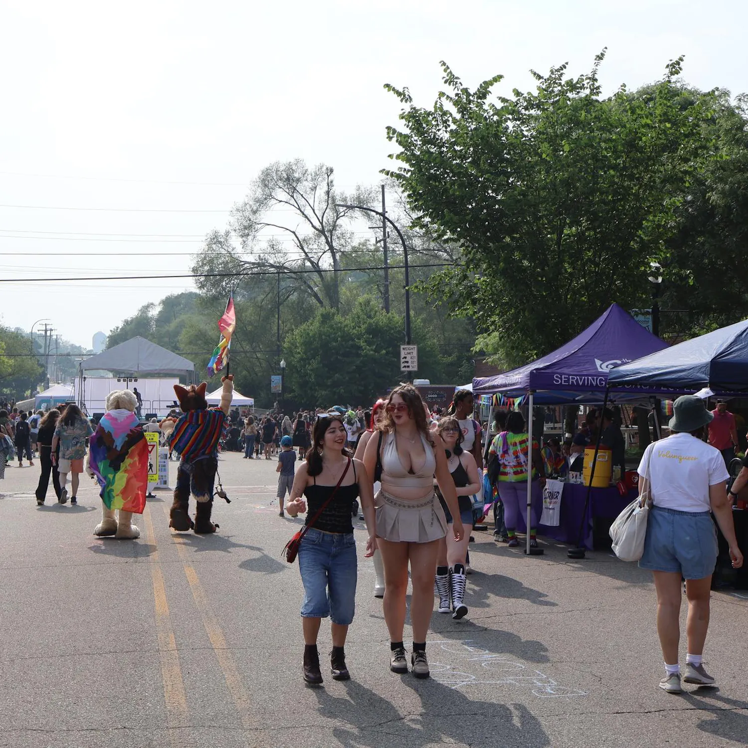 A crowd of people smiling as they explore Ypsi Pride 2025