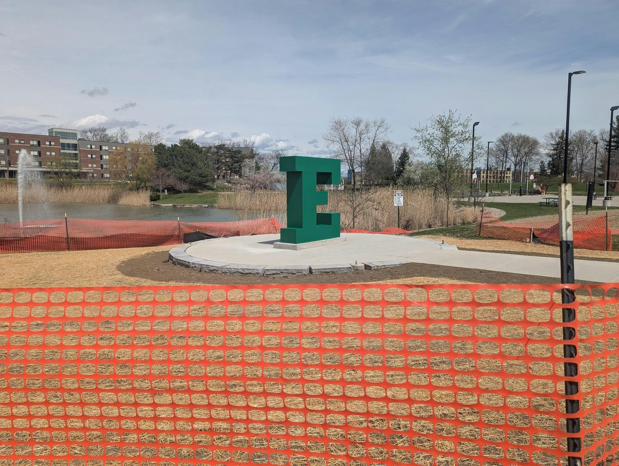 Orange construction fencing blocks off the new sculpture, a giant block "E." 