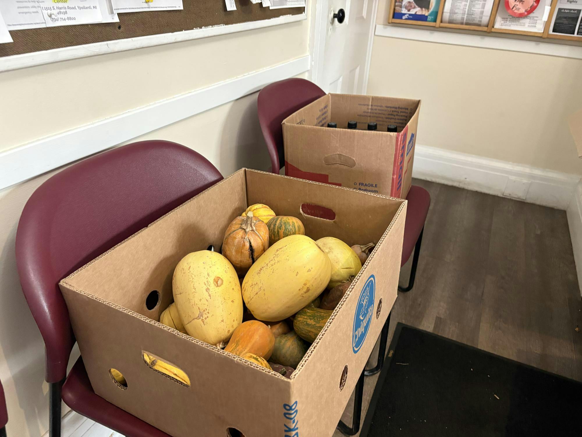 An image of a box of squash sitting on top of a red chair.