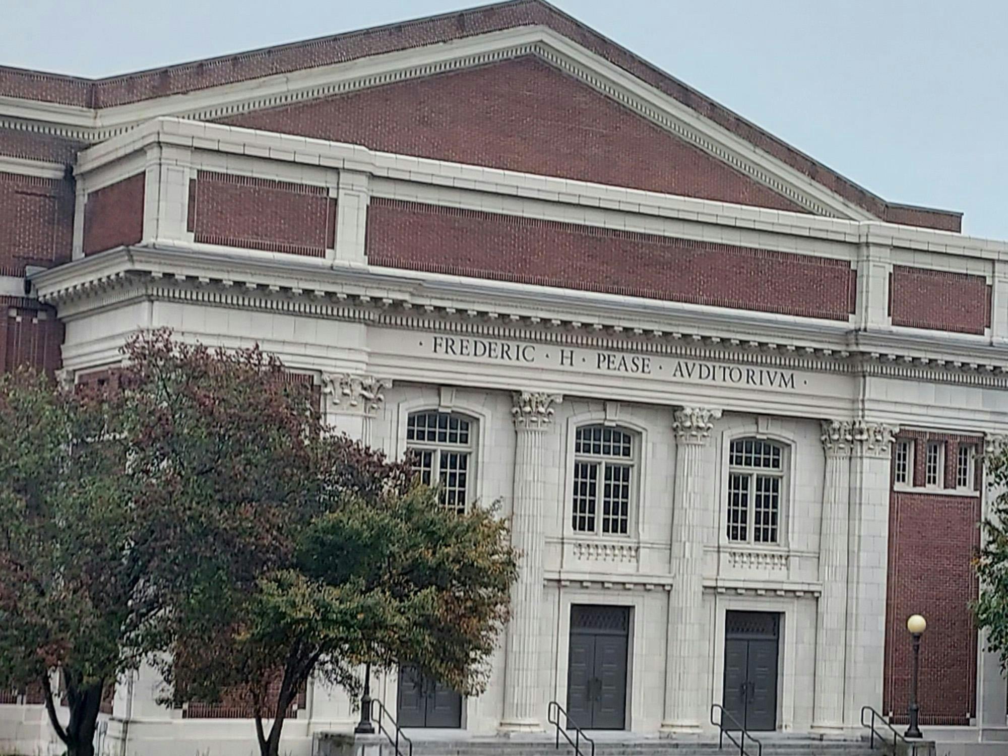 Pease Auditorium at EMU is a large building made of red bricks and tall white columns.