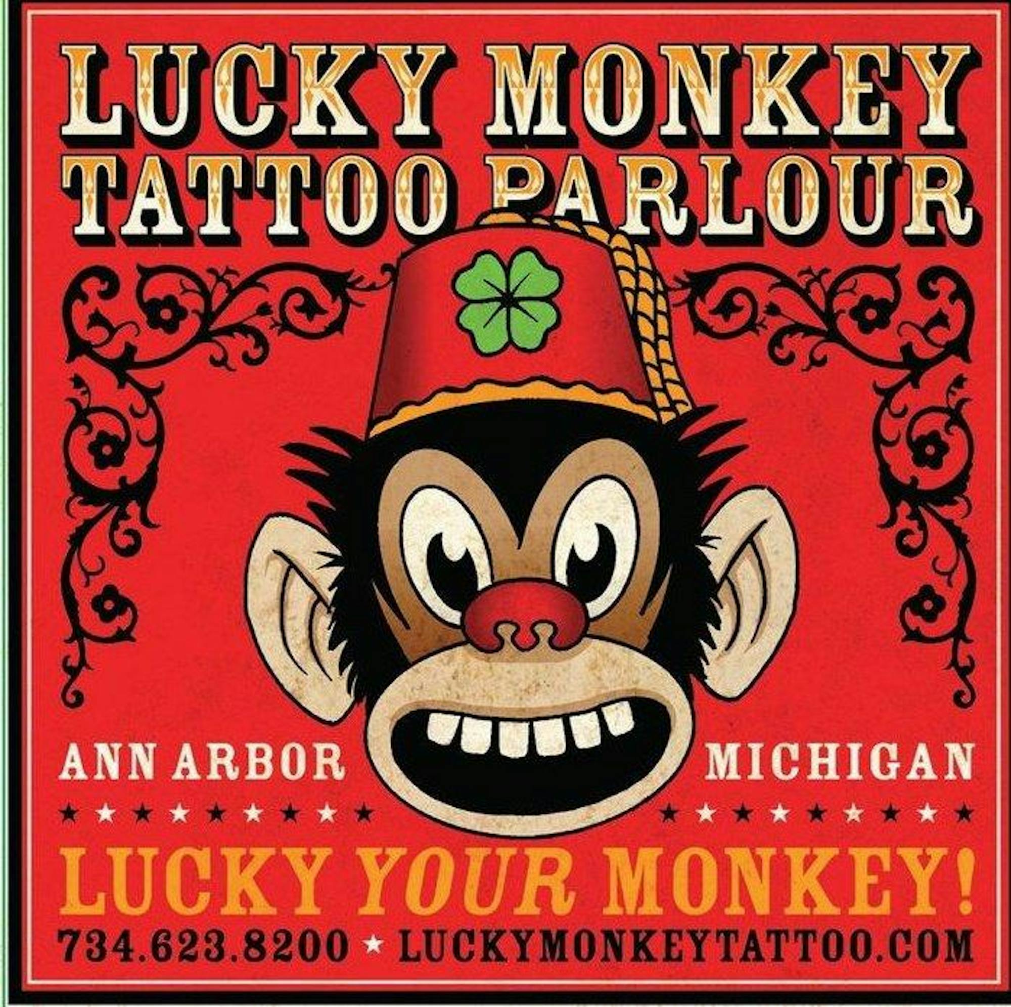Old, 1800s circus-style logo of the head of a monkey smiling and wearing a red hat with a 4-leaf clover.