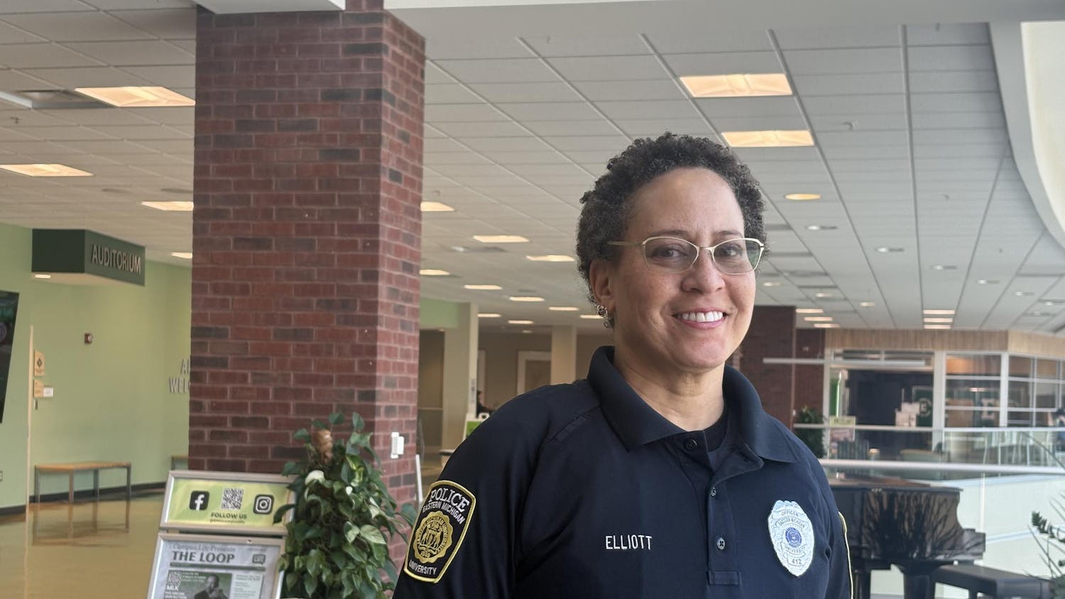 Officer Elliott smiles and stands in uniform in the Student Center.