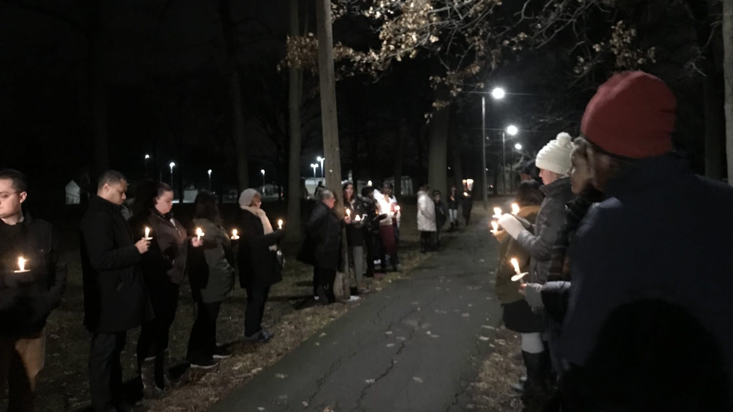 Mourners hold candles in remembrance of Brian "Trey" Matthews III.