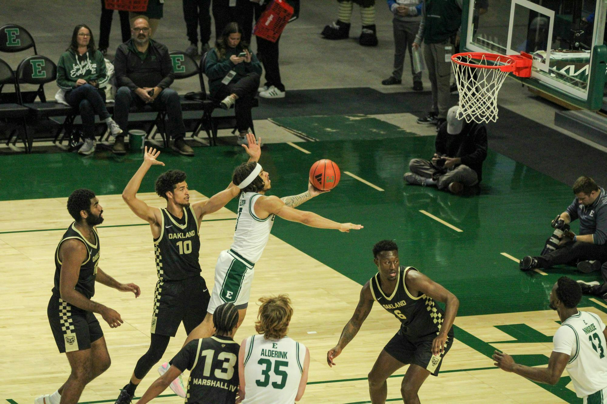 #3, in a white jersey, shooting with Oakland players around, in black jerseys. 