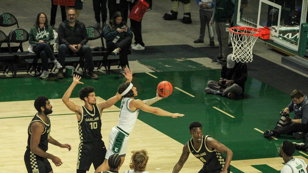 #3, in a white jersey, shooting with Oakland players around, in black jerseys.
