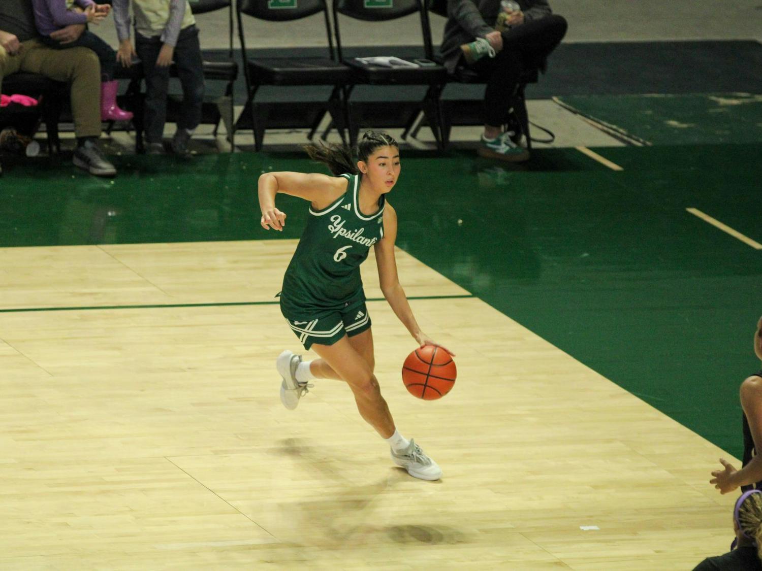#6 Fernanda Ovalle, in a green Eastern Michigan University jersey, dribbling the ball.