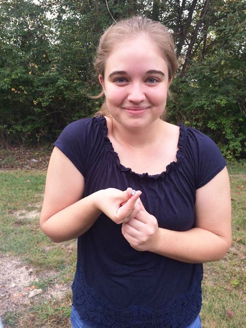 Sophomore Alyssa Roat poses with a “gem” she discovered inside a magnetic cache. (Photograph by Hope Bolinger)