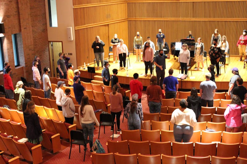 Taylor Chorale students hold rehearsals in the recital hall while maintaining distance by utilizing the stage, aisles, and seats. (Photo by Anna Collins)