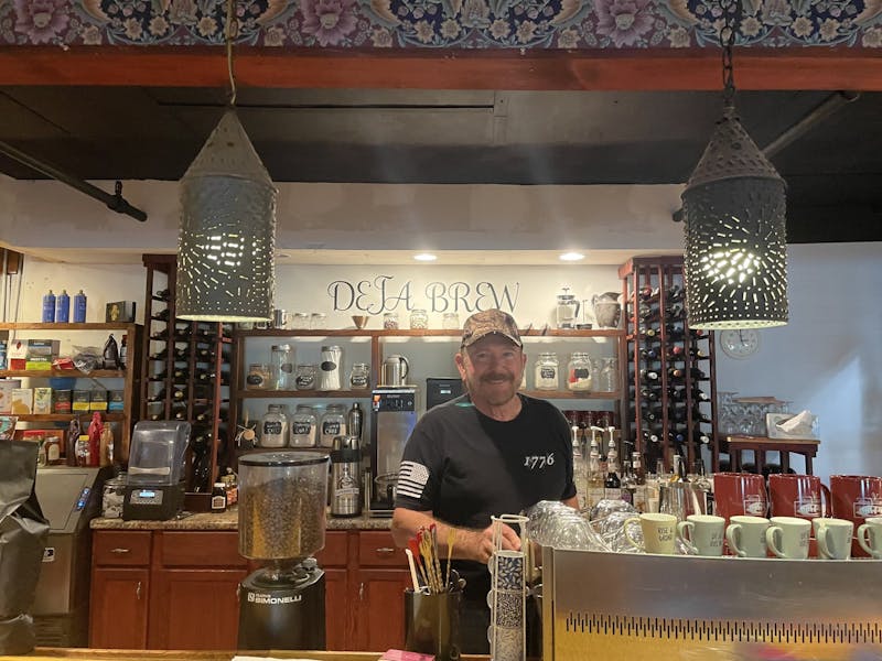 Gordon Jackson stands behind the bar in his glass factory turned coffee shop. 