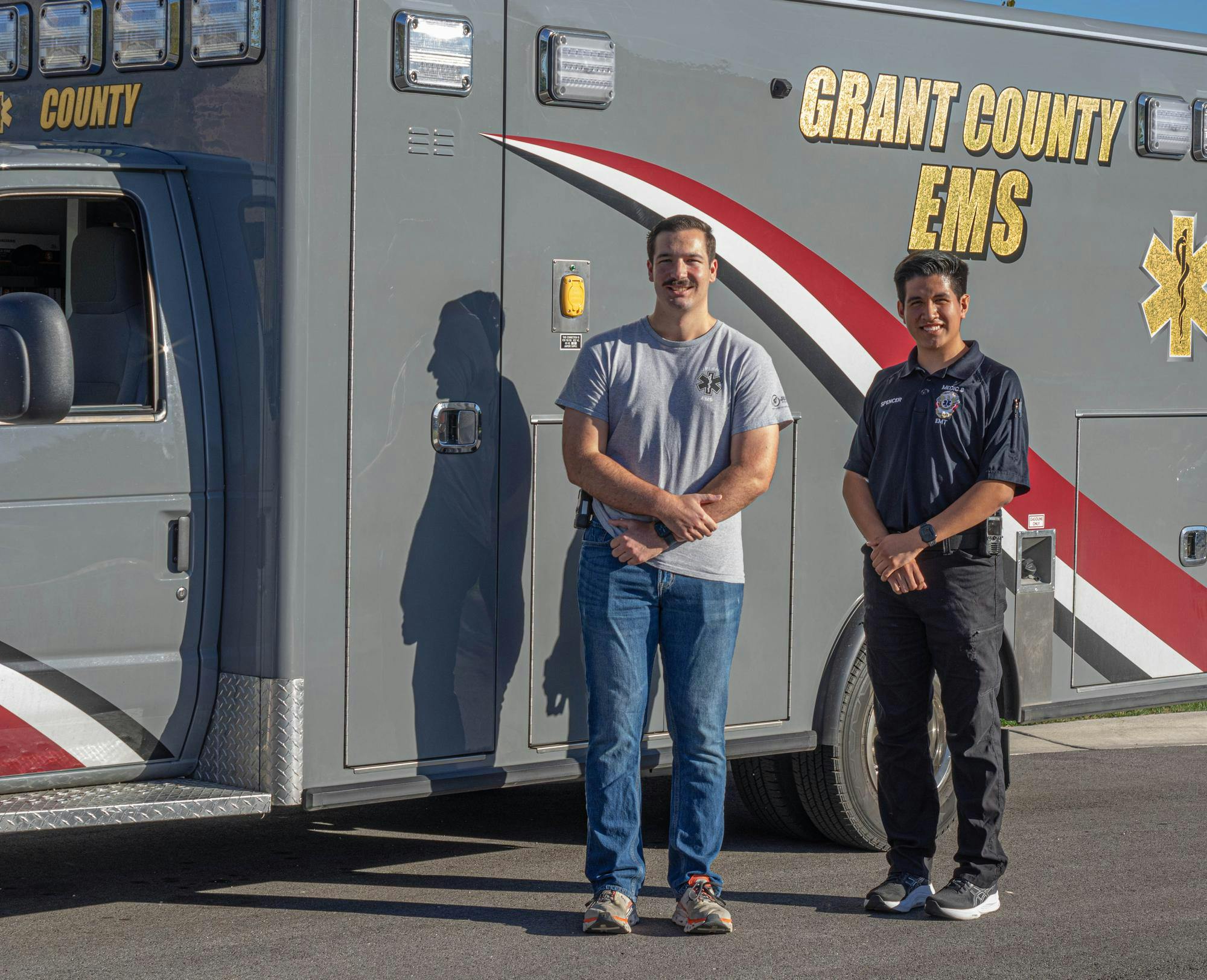 Senior Carter McHugh, left, and junior Spencer Pardee stand in front of a Grant County EMS vehicle.