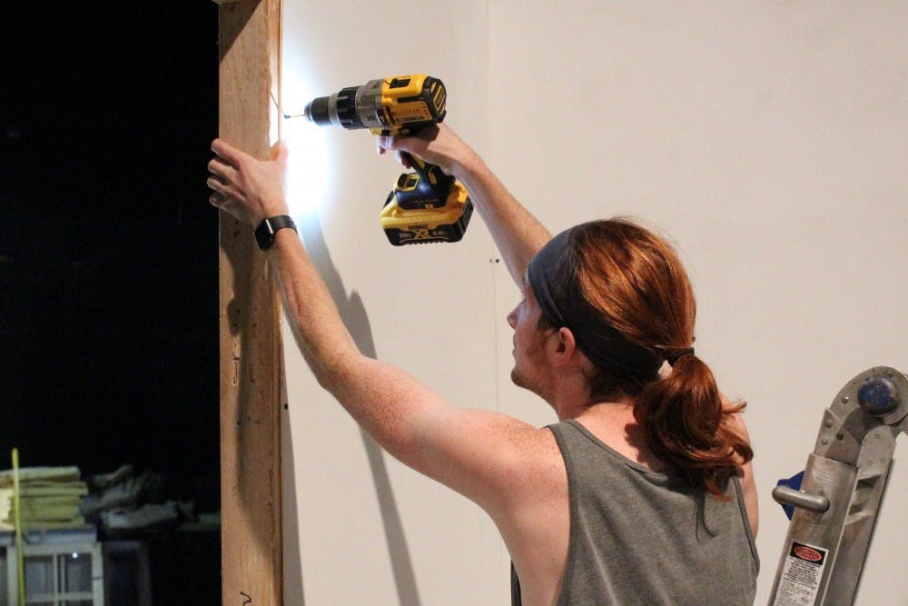 Conner Reagan works on building the set for “Falling”