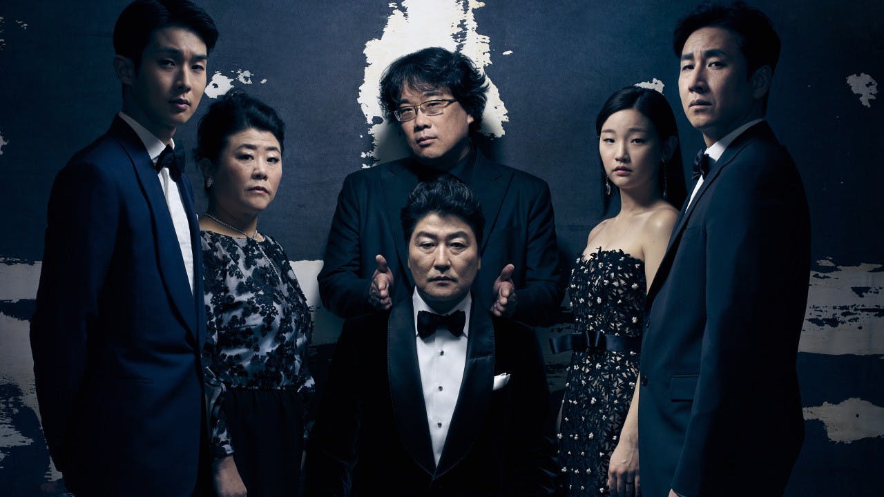 The director and cast of “Parasite” pose after winning Oscar for Best Picture.