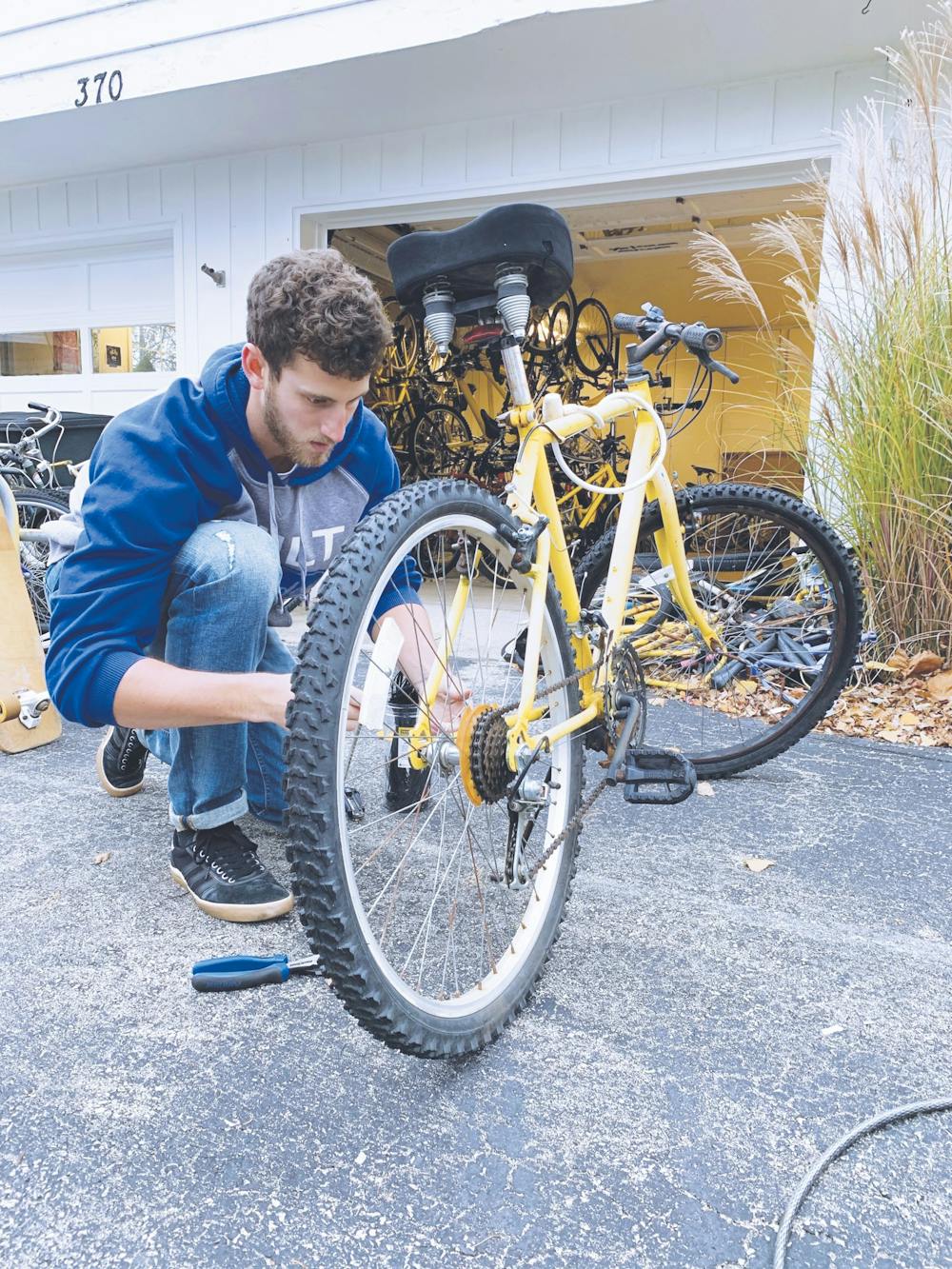 Matt Wildman works on tuning up the rental bikes before distribution PRINT.jpg